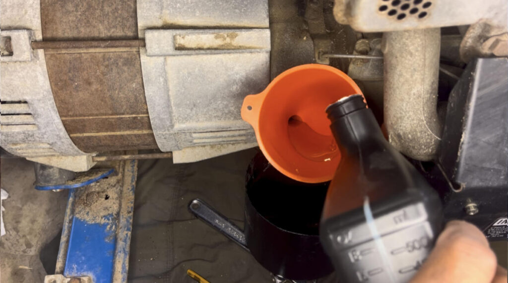 Pouring SAE 30 oil into a PowerBack 5250 generator using a funnel.