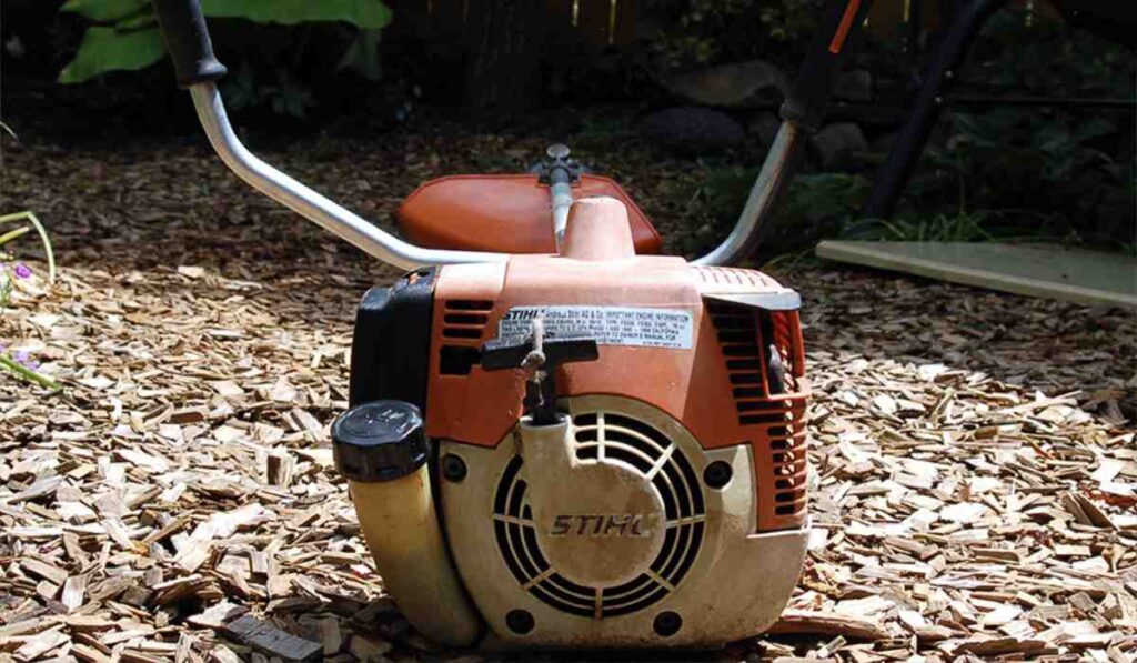 Fully restored Stihl FS 200 professional brushcutter sitting on woodchips.
