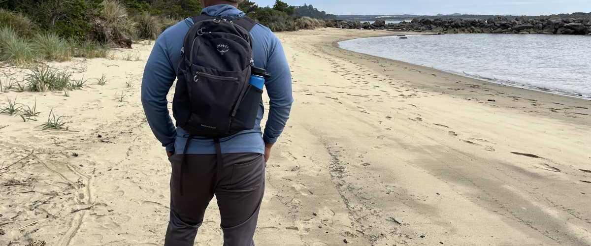 Earl Gibson reviewing the Osprey Daylite Plus backpack on a driftwood-covered beach at Heceta, Oregon.