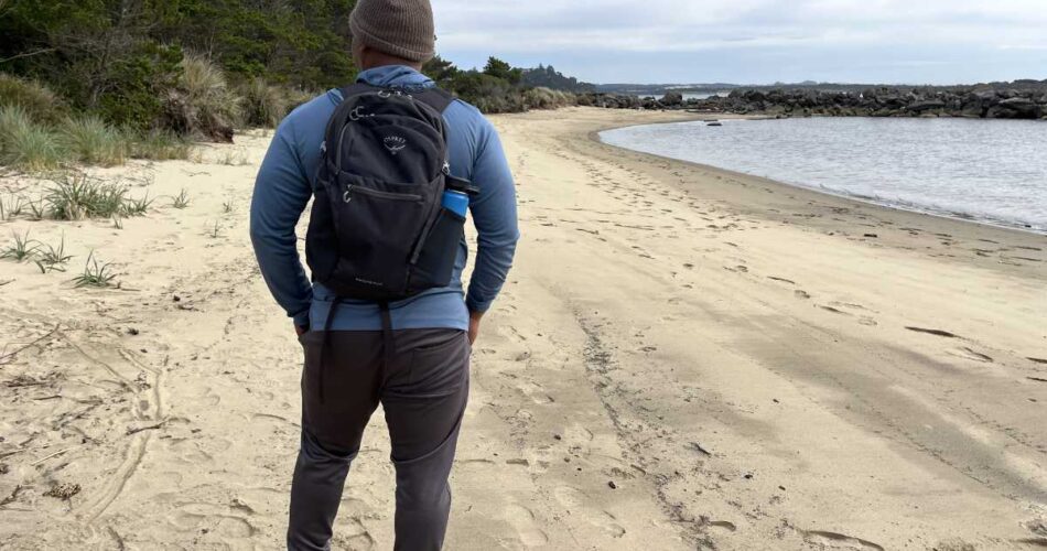 Earl Gibson reviewing the Osprey Daylite Plus backpack on a driftwood-covered beach at Heceta, Oregon.