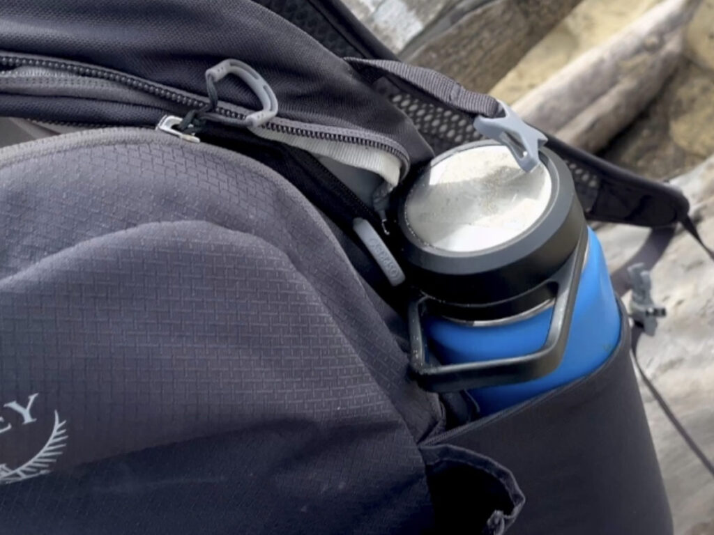 water bottle holder of an Osprey Daylite Plus packed with weekend travel gear and outdoor essentials.