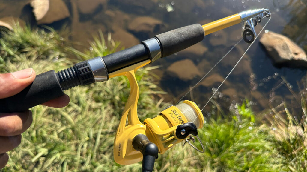 Eagle Claw Pack-It yellow spinning reel attached to rod handle