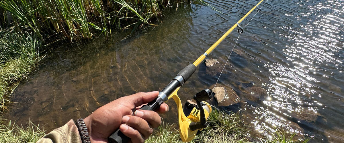 Angler holding extended yellow Eagle Claw Pack-It telescopic rod over water