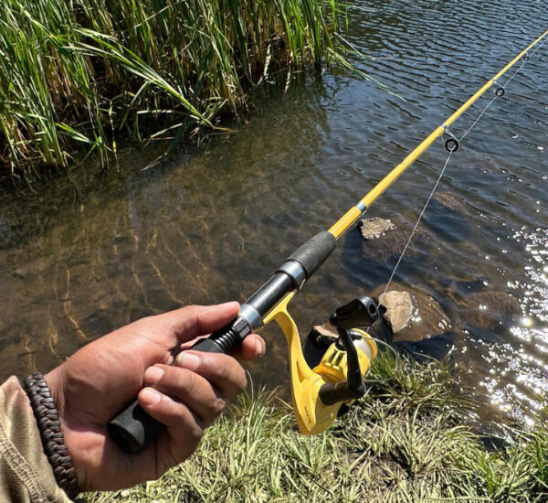 Angler holding extended yellow Eagle Claw Pack-It telescopic rod over water
